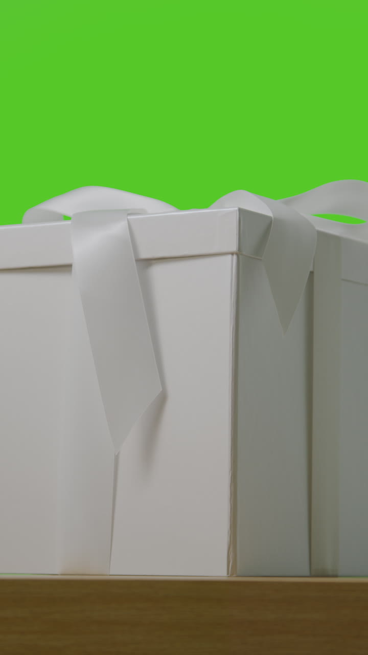 테이블 위에 리본으로 장식 된 선물 포장 상자에 있는 선물의 수직 비디오 녹색 스크린 1에 대 한