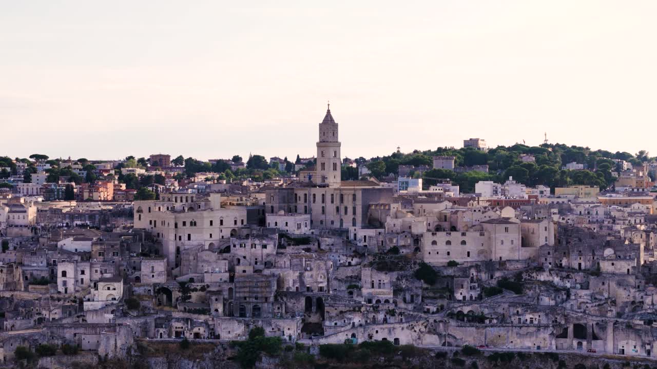 Matera township and church tower during golden hour, aerial view
