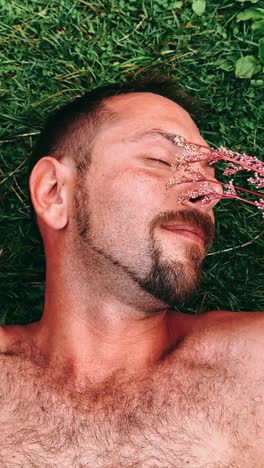 man relaxing in grass with flowers