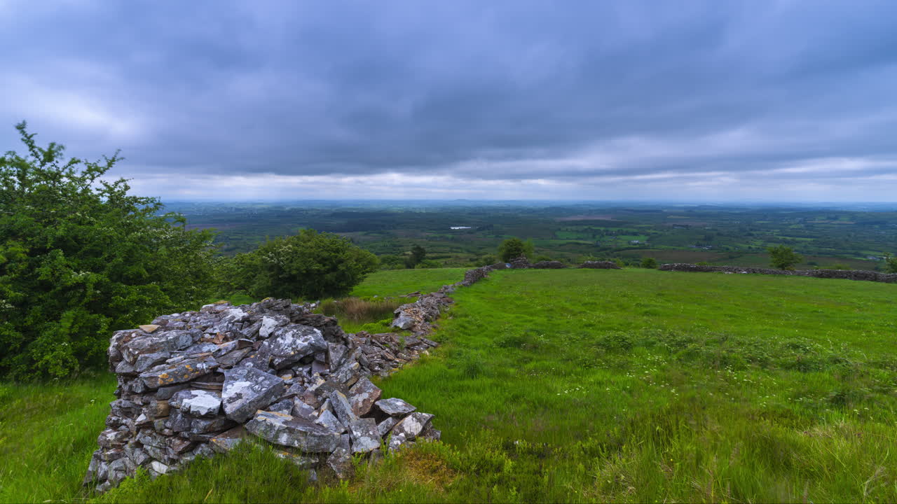 Time lapse of rural landscape with trees and rocky wall in grassland on a spring cloudy day in Arigna mountains in county Leitrim in Ireland