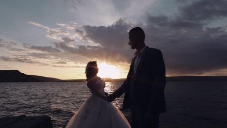 Pareja-De-Recién-Casados-En-La-Ladera-De-Una-Montaña-Junto-Al-Mar.-Atardecer.-Novio-Y-Novia