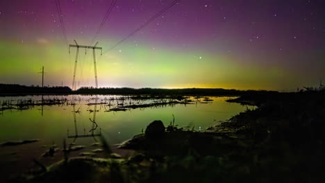 Beautiful-green-purple-aurora-glow-reflects-on-water-as-stars-pass-in-night-sky