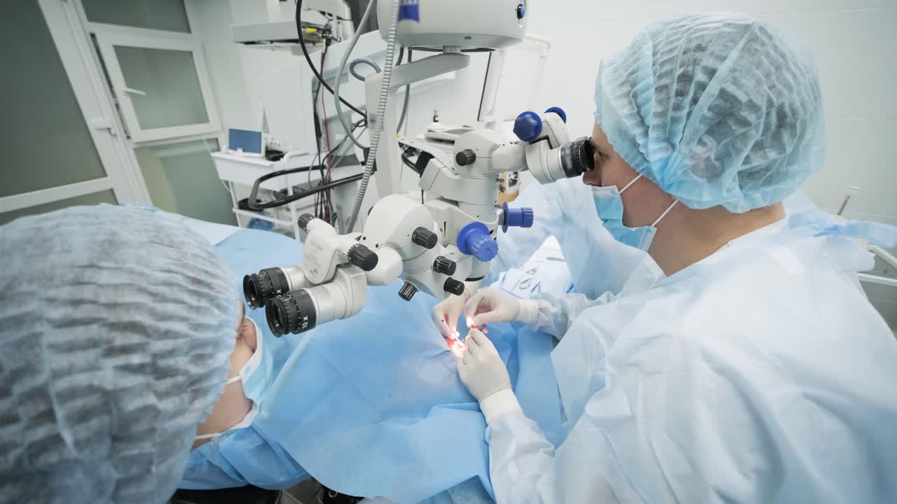 Equipo quirúrgico realizando cirugía de estrabismo utilizando tecnologías modernas, los últimos dispositivos, microscopio en una clínica moderna