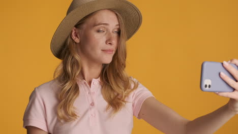 caucasian woman in a hat having video call on smartphone.