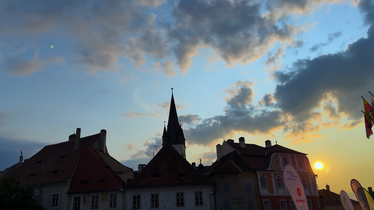 Sibiu, Romania, 1 July 2025: Evening skyline of Sibiu rooftops with church tower. Colorful old town rooftops and the Evangelical Cathedral tower at dusk in Sibiu, Romania