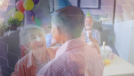 animación de luz brillante sobre una pareja mayor sonriente con sombreros de fiesta bailando en una fiesta
