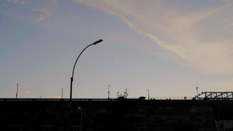 silhouette of pedestrians walking across the brooklyn bridge