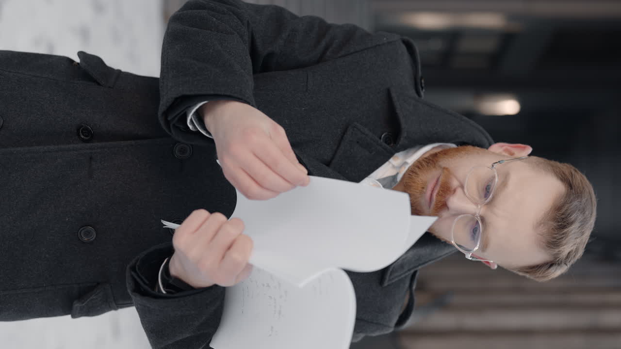 Man in coat reading document