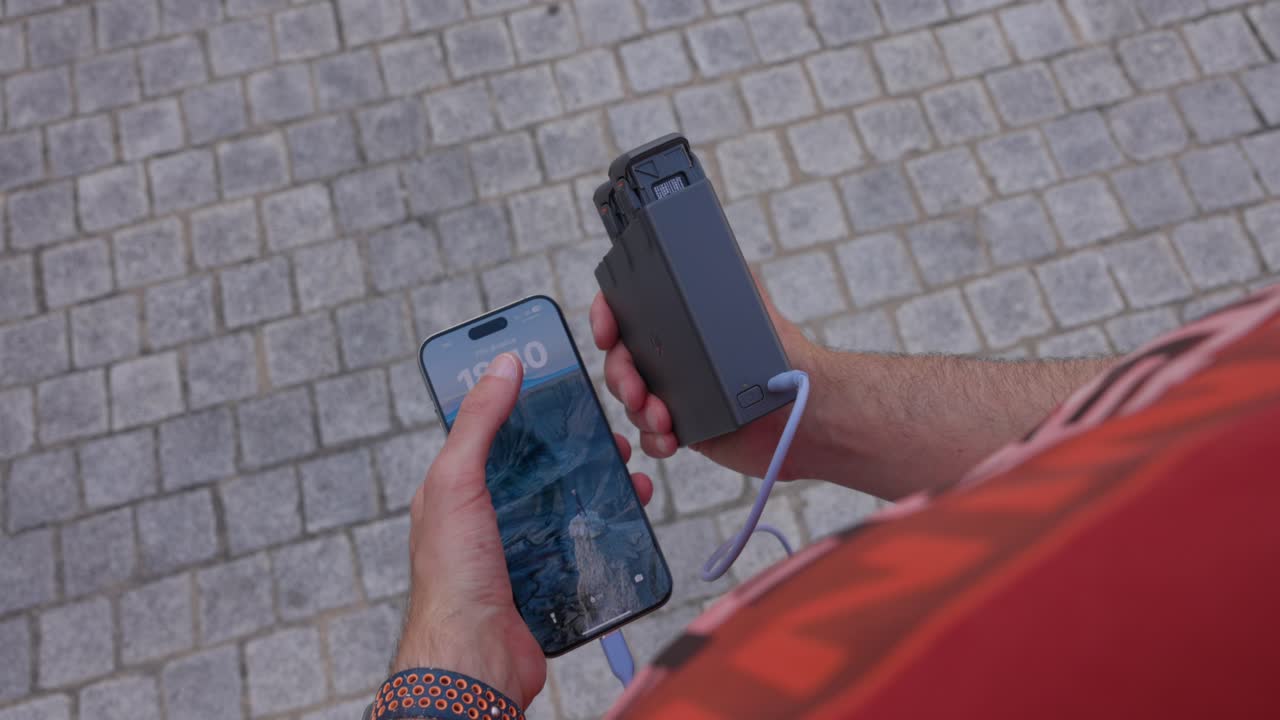 Charging Smartphone With FPV Drone Charging Hub. overhead shot