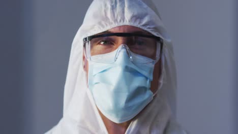 retrato de un trabajador médico caucásico con ropa de protección con máscara y gafas de seguridad