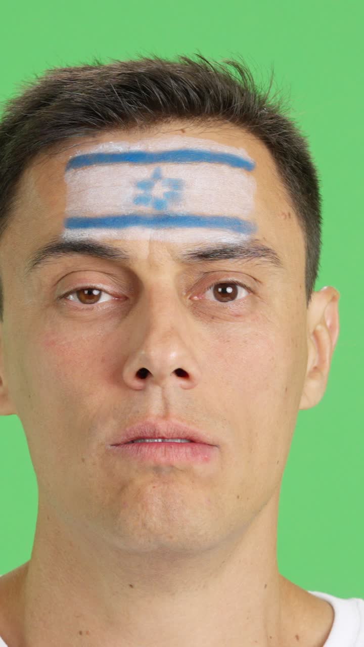 Man with a israeli flag painted on the face smiling
