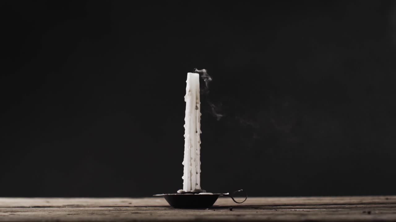 video de una vela de halloween con humo y espacio de copia sobre un fondo de madera y negro