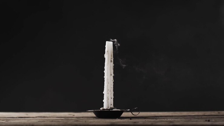 Video of halloween candle with smoke and copy space on wooden and black background