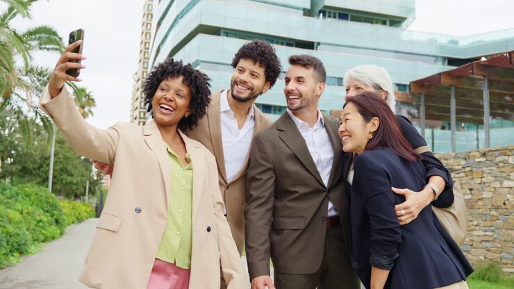 Group of diverse professionals taking a selfie outdoors