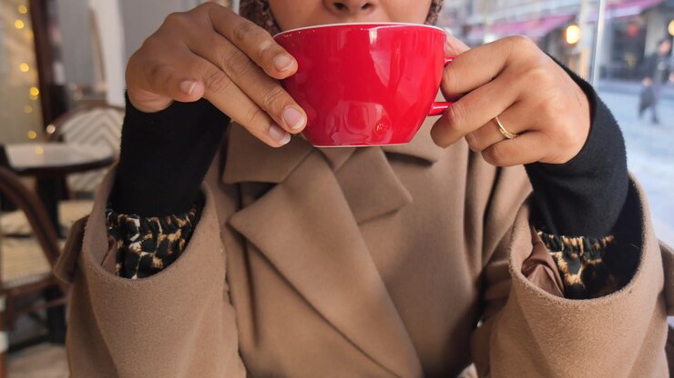 Close-up of Woman Holding Red Coffee Cup in Cafe