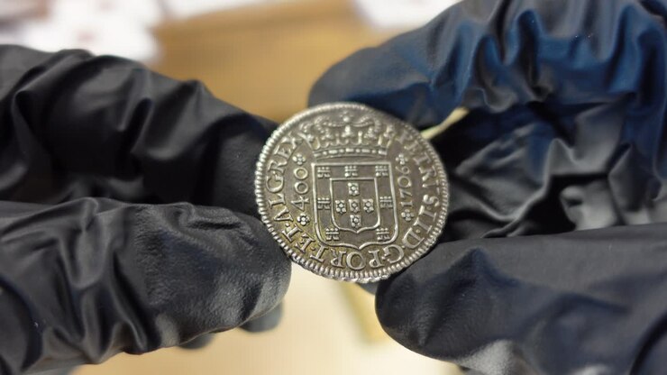 Collector examining Portuguese Silver coin from the Modern Age