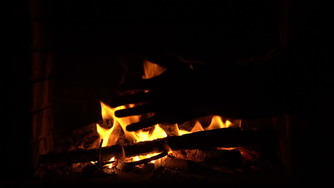 Warming hands in the fire in the fireplace