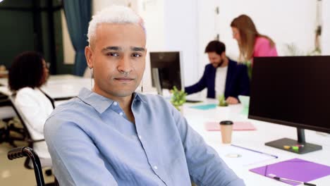 uomo etnico infortunato felice in ufficio con i colleghi
