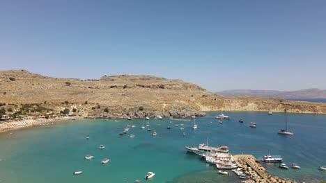 Playa-Lindos,-Famosa-Bahía-De-Rodas,-Grecia-Con-Muchos-Barcos-Atracados,-Plataforma-Rodante-Aérea