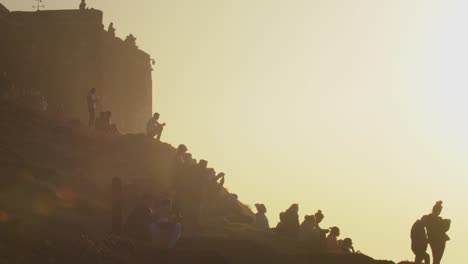 Crowd-of-people-watching-surfers-at-Nazaré-beach-in-Portugal,-famous-for-it's-huge-waves