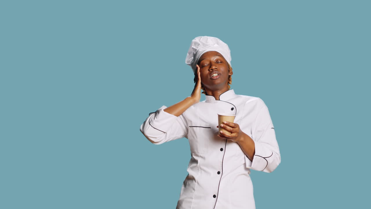 Chef esausto che sbadiglia e beve caffè davanti alla telecamera