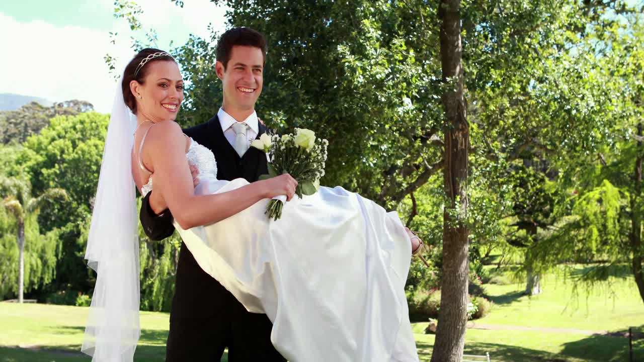 el novio recogiendo a su nueva y bonita esposa