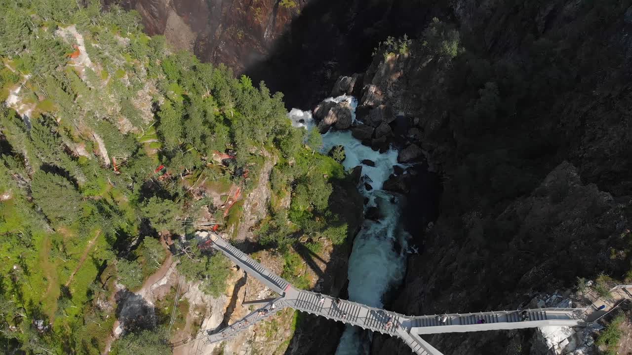vista aérea de los turistas cruzando el nuevo puente en las cataratas voringsfossen, noruega