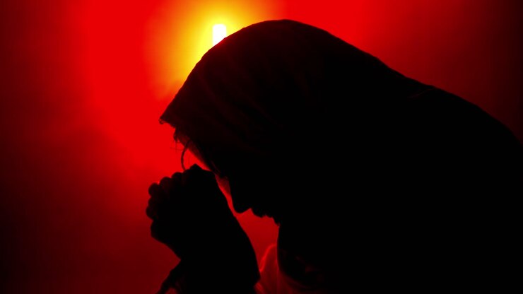 Dramatic, stylistic, Jesus Christ in praying, worshipping in red glowing light for Christianity, Easter visual, bible scene or temptation, prayer, worship visual.