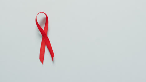Video-of-red-blood-cancer-ribbon-on-pale-blue-background