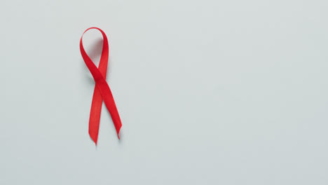 video of red blood cancer ribbon on pale blue background