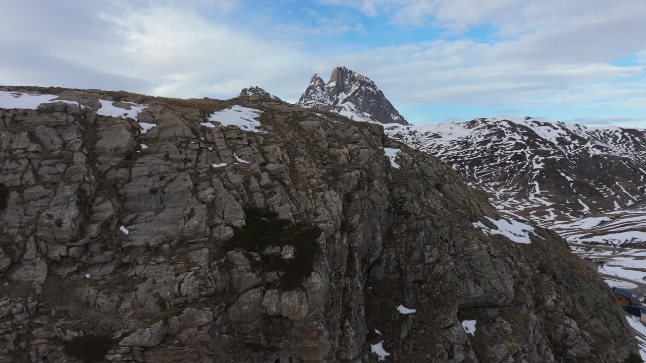Drone revealing movement the snowy mountain Pic du Midi d'Ossau in France from the Portalet sky station in Spain