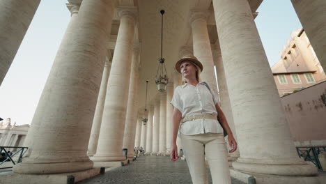 woman walking under columns in st. peter's square