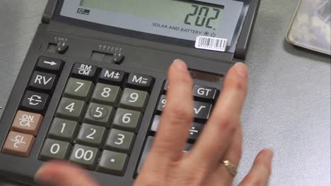 primer plano de la mano de una mujer trabajando en una calculadora para calcular los datos comerciales, los gastos y el presupuesto doméstico