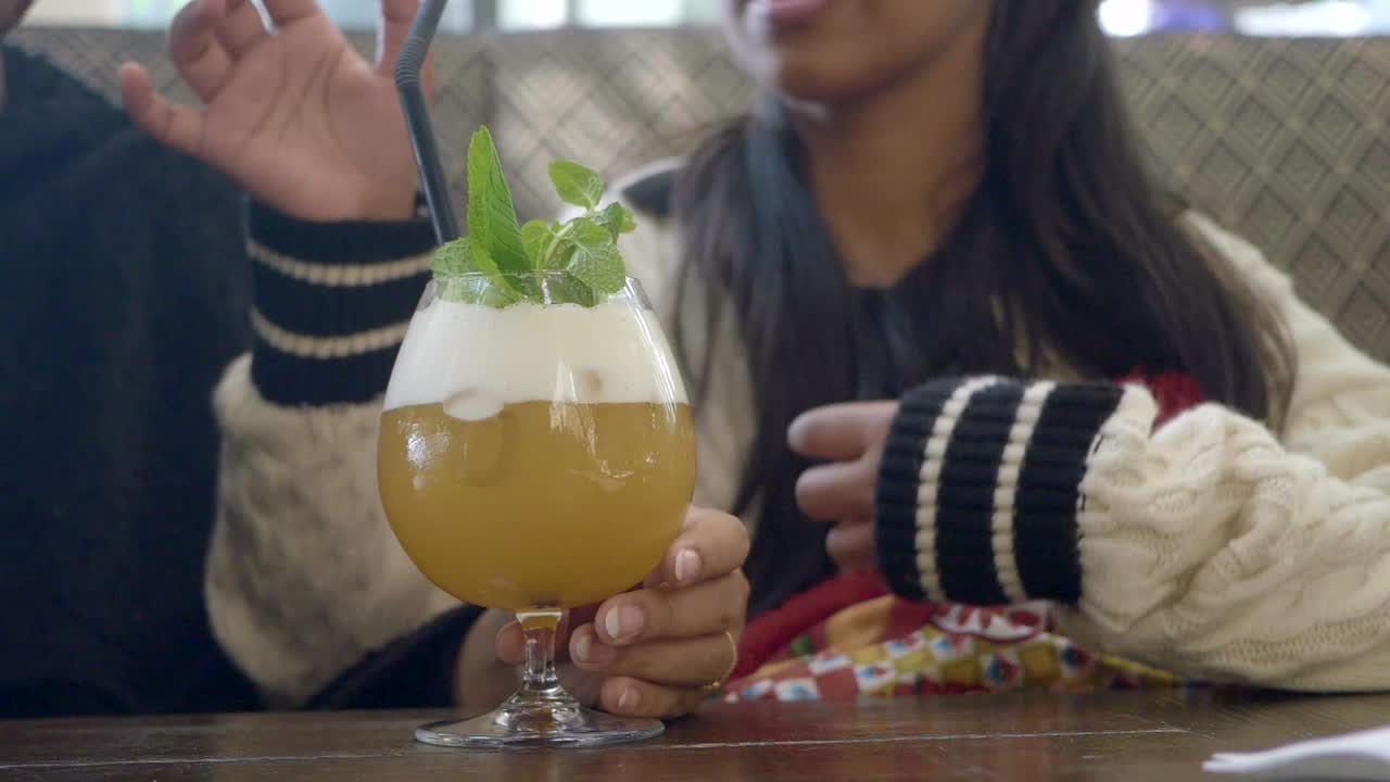 Woman drinking cocktail with straw and mint