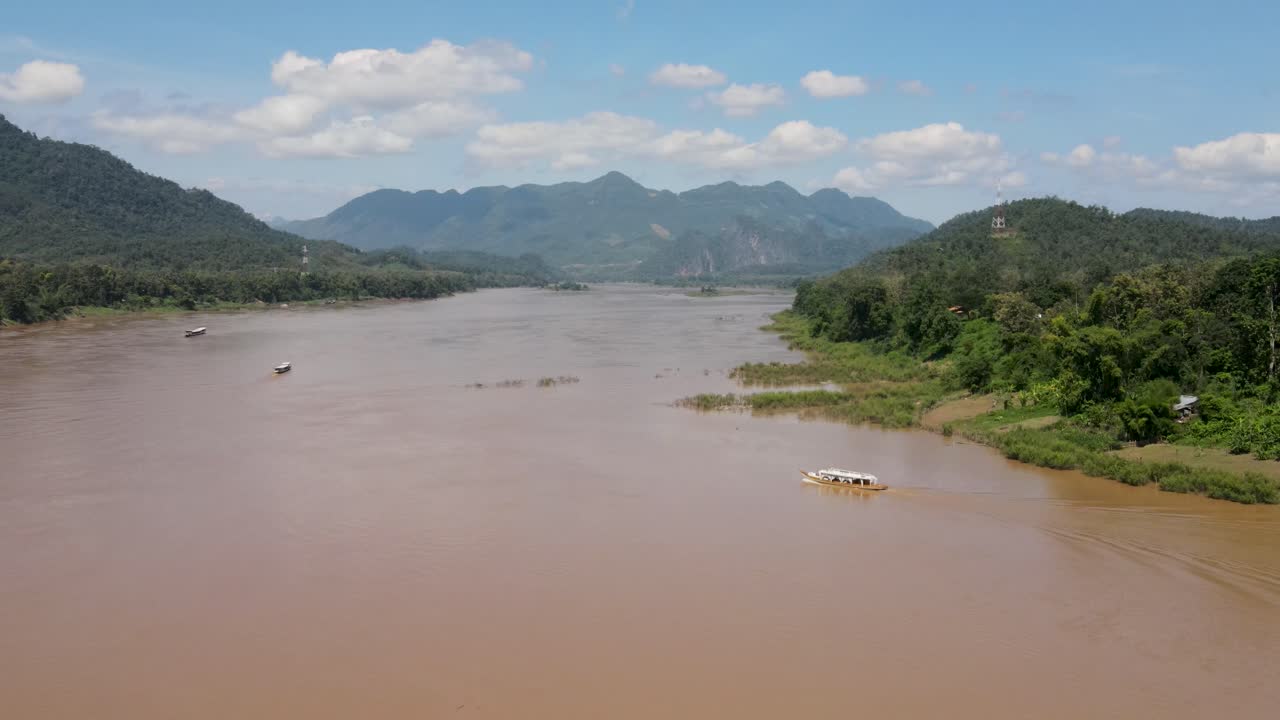 Veduta aerea sul possente fiume Mekong in una giornata di sole con una barca fluviale che lo attraversa a Luang Prabang