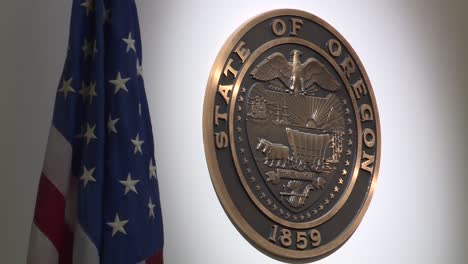 state of oregon seal next to american flag in court room