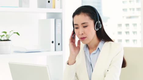 asian businesswoman using headset and laptop