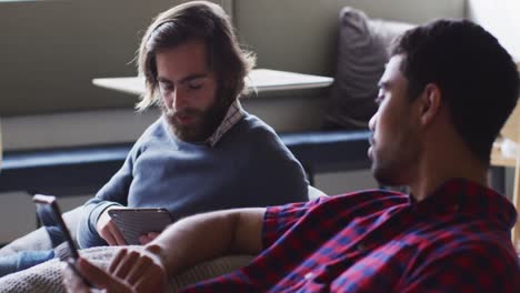 diverse business people sitting using digital tablet and smartphone in modern office