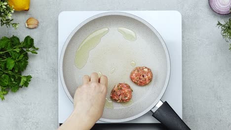 persona irreconocible fritando albóndigas para el almuerzo
