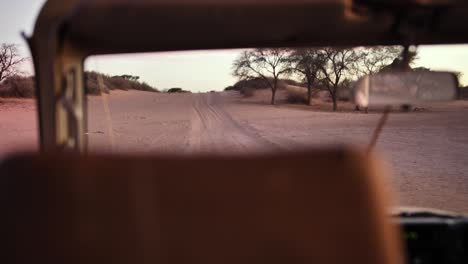 coche de safari está conduciendo a través del desierto de namibia en un camino lleno de baches