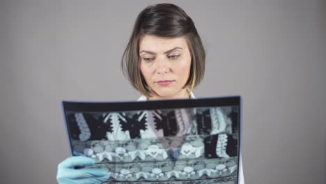 Young-female-nurse-reviewing-x-rays-isolated-on-white-background.-Healthcare-concept.-Shot-in-4k