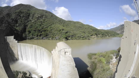 Wide-time-lapse-dolly-shot-from-above-Matilija-Creek-spilling-over-an-obsolete-Matilija-Dam