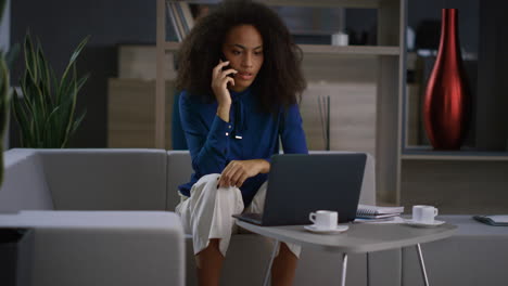 African-american-businesswoman-discuss-financial-report-by-cell-phone-in-office.