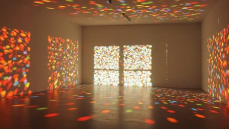 an artistic display of colorful light patterns projected on a bare wall, creating a unique visual experience in an empty room