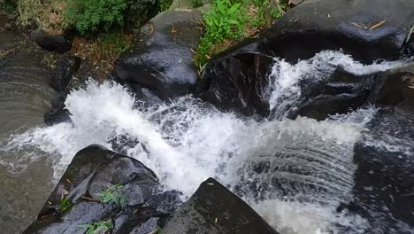 急流的河水流過黑色的岩石