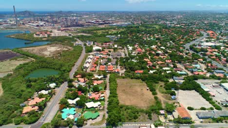 drone trucking pan tilt up across sprawling neighborhoods and oil refinery on curacao