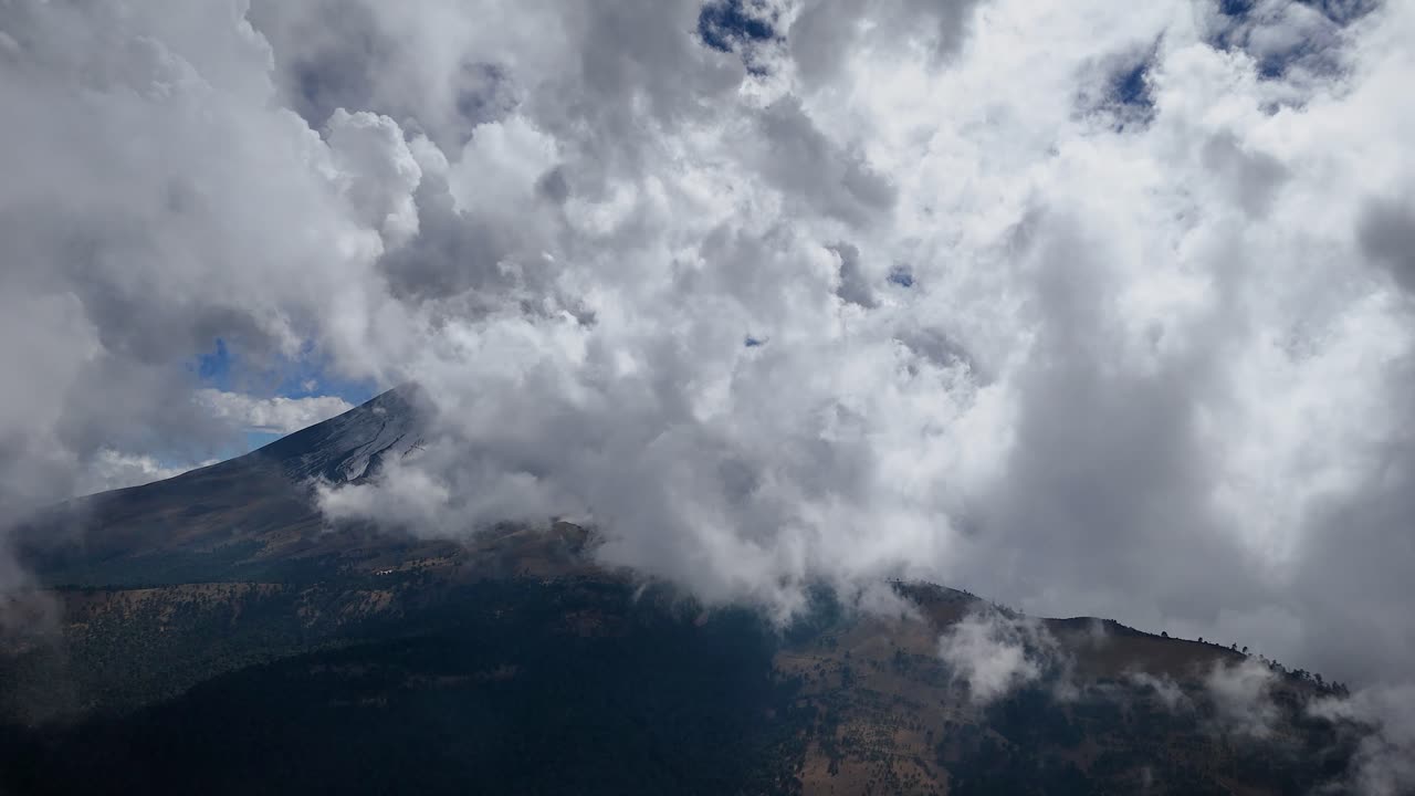 Aerial drone shot navigating through clouds near the Popocatépetl volcano, near Mexico City