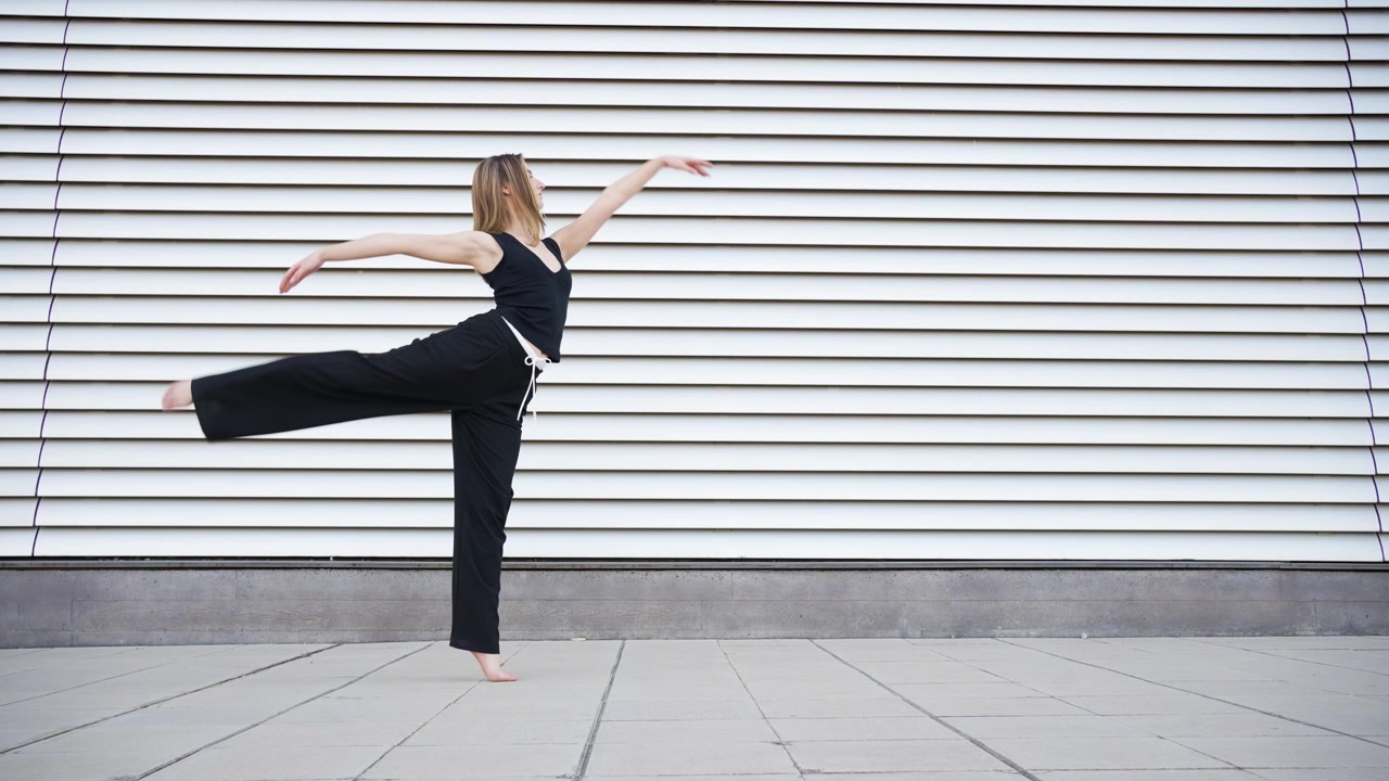 Il movimento di danza espressiva e accattivante contrasta fortemente con le forme architettoniche moderne.