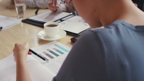 steadicam shot in of diverse business team meeting showing progress graph