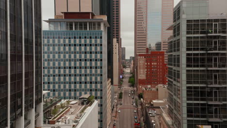 Forwards-flying-drone-along-street-with-tall-buildings.-Aerial-view-of-downtown-towards-Comerica-Bank-Tower.-Various-height-of-buildings-around.-Dallas,-Texas,-US